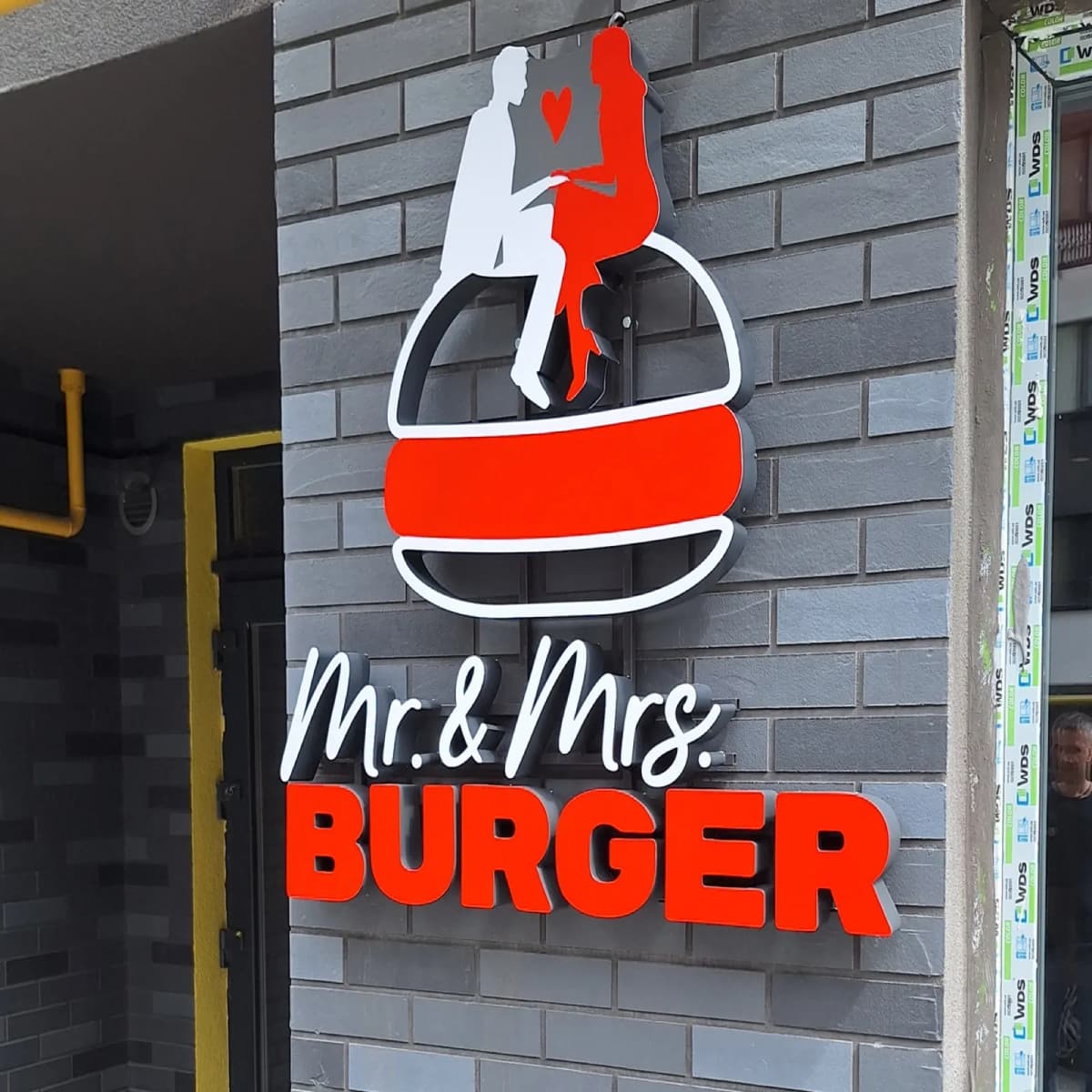Mr. & Mrs. Burger 3D sign: a white and red burger logo above the lettering on a brick wall