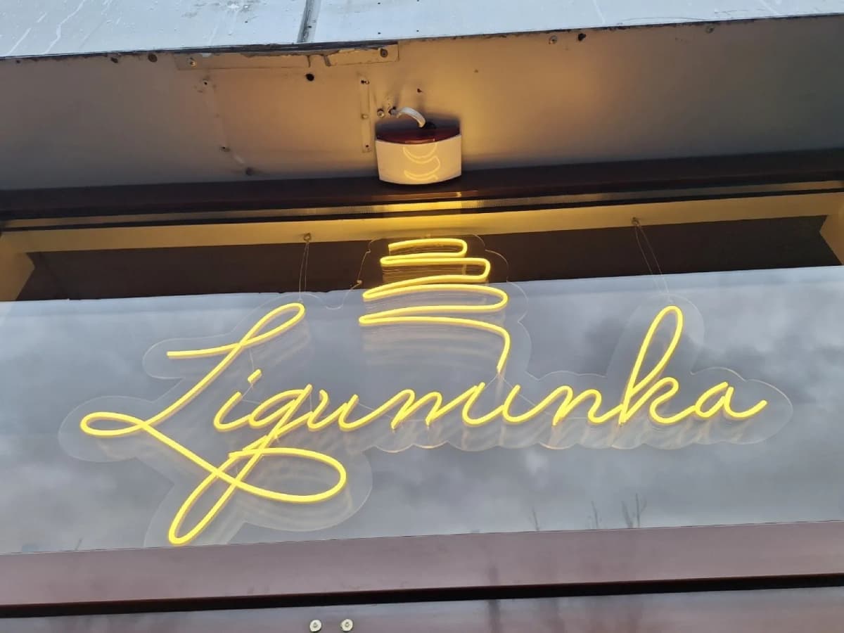 Yellow neon sign “Ziguminka” in a coffee-shop window