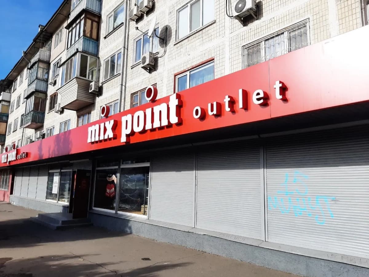 Red facade sign with 3D letters “mix point outlet” on a shop