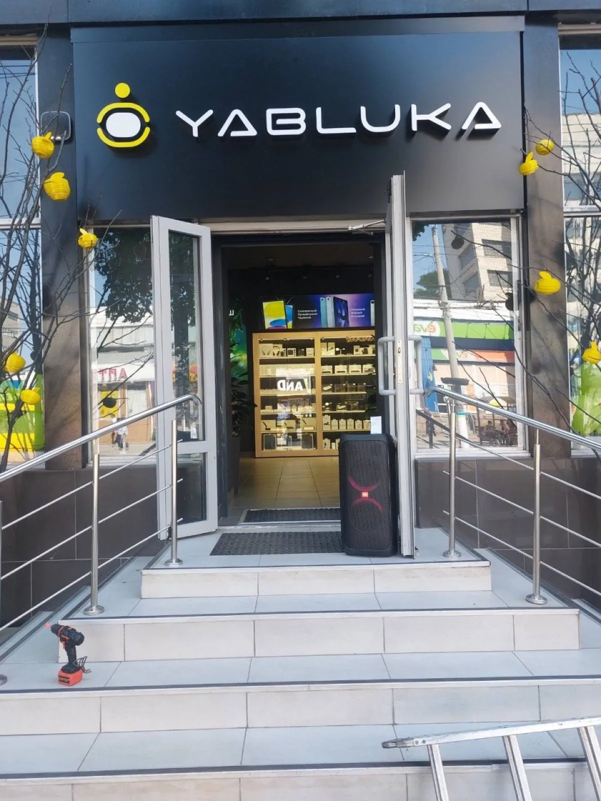 Вхід у магазин YABLUKA вдень із чорною вивіскою над скляними дверима
