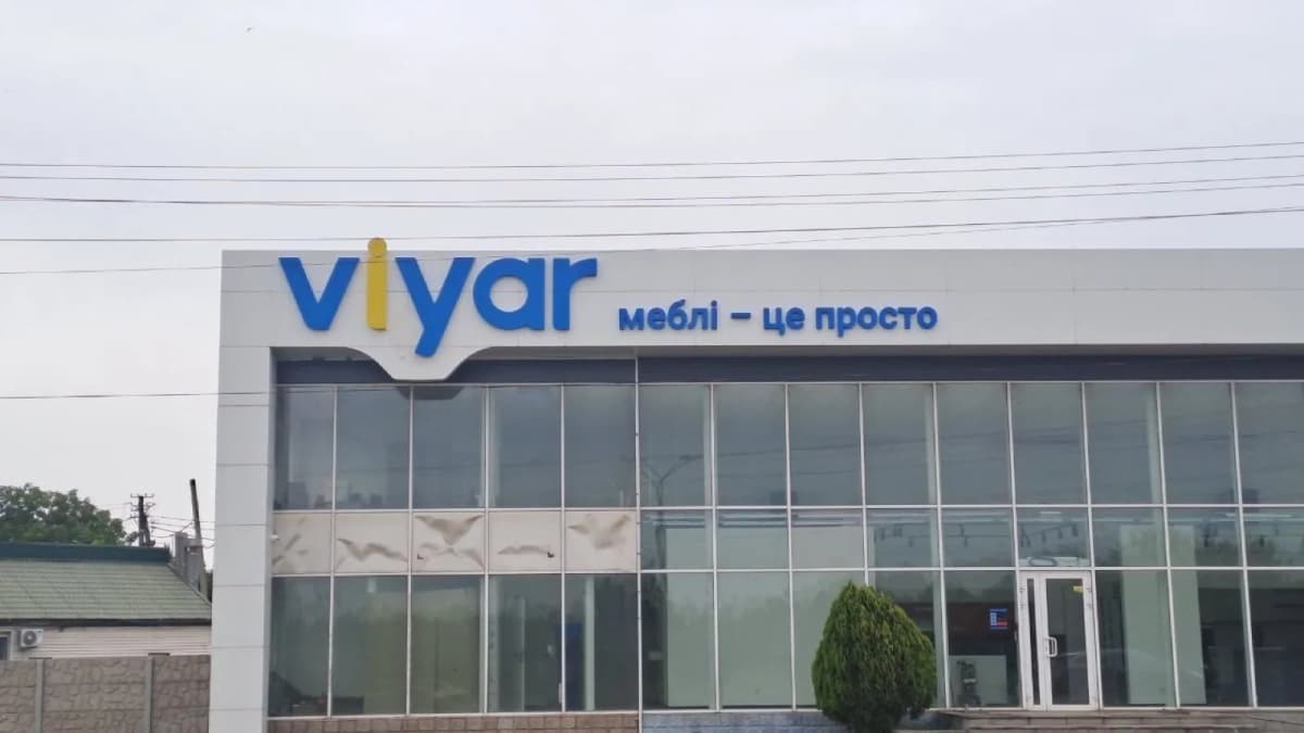 Long pale facade of a viyar showroom with blue lettering above the windows