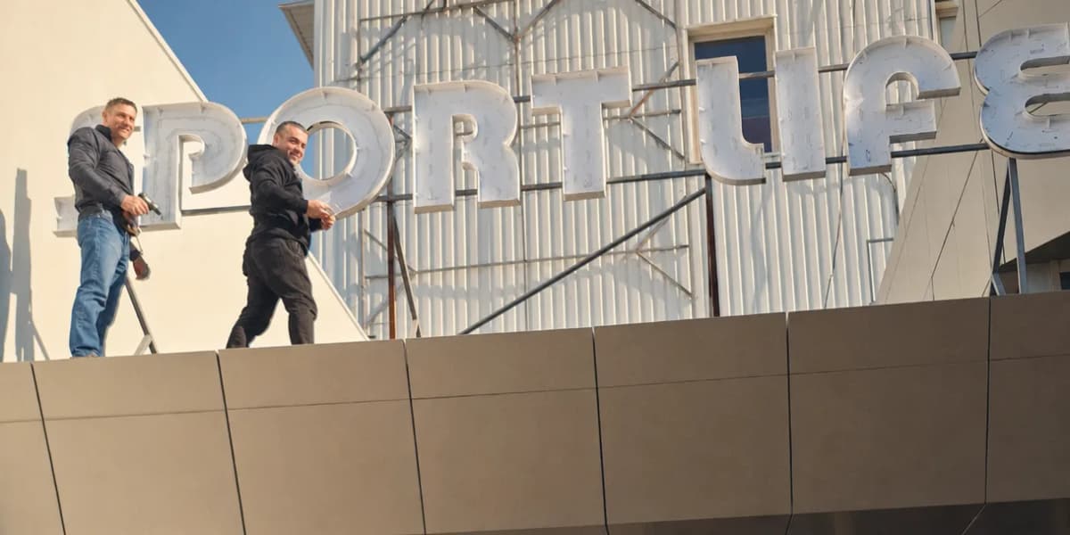Two TheFace installers fitting 3D letters onto a shopping-centre facade